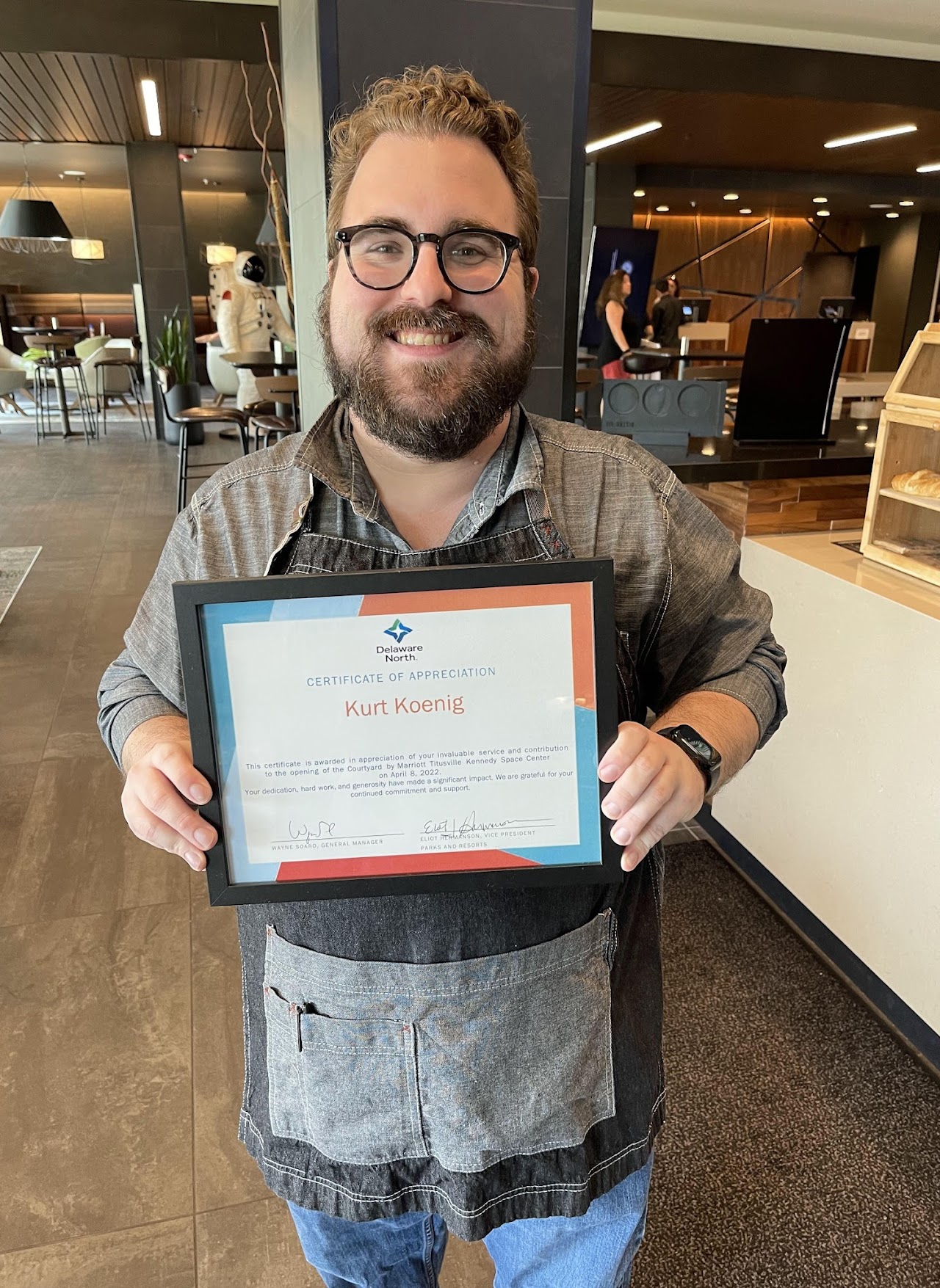 Kurt holding a certificate of appreciation at the Courtyard by Marriott