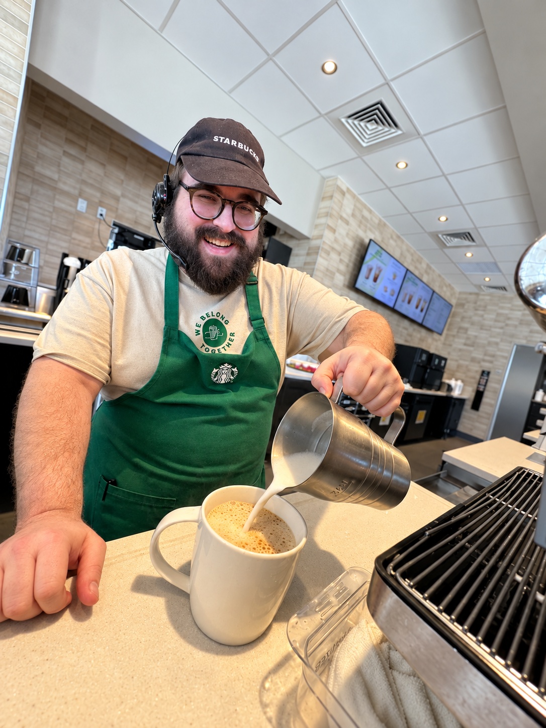 Kurt pouring milk behind the coffee bar